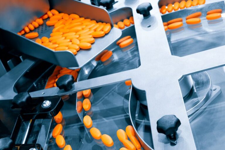 Pills on a conveyor in a pharmaceutical manufacturing plant.